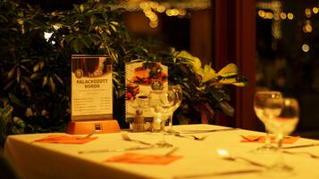 A restaurant table set with a menu, wine glasses, and cutlery.