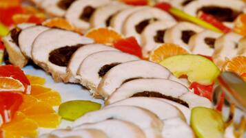 A sliced meat dish with fruit garnish.