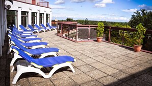 A rooftop terrace with sun loungers and potted plants. - Hotel Lövér Sopron (Sopron)