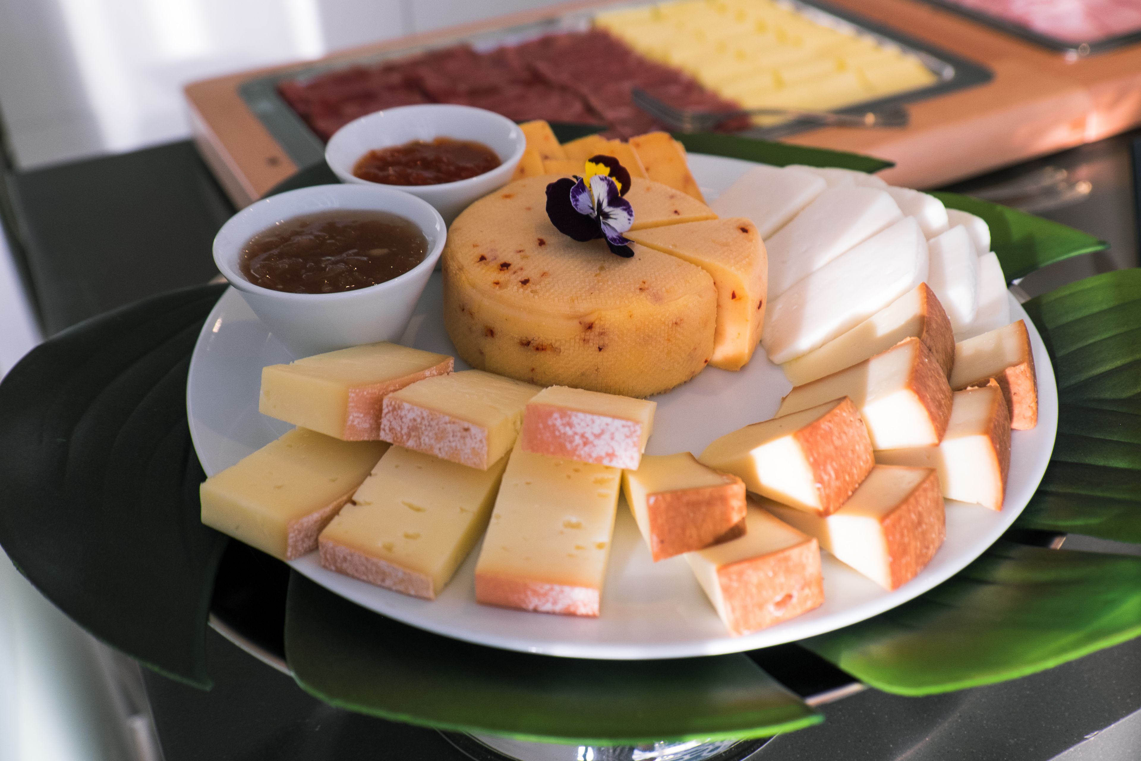 A plate of assorted cheeses and accompaniments on a table.