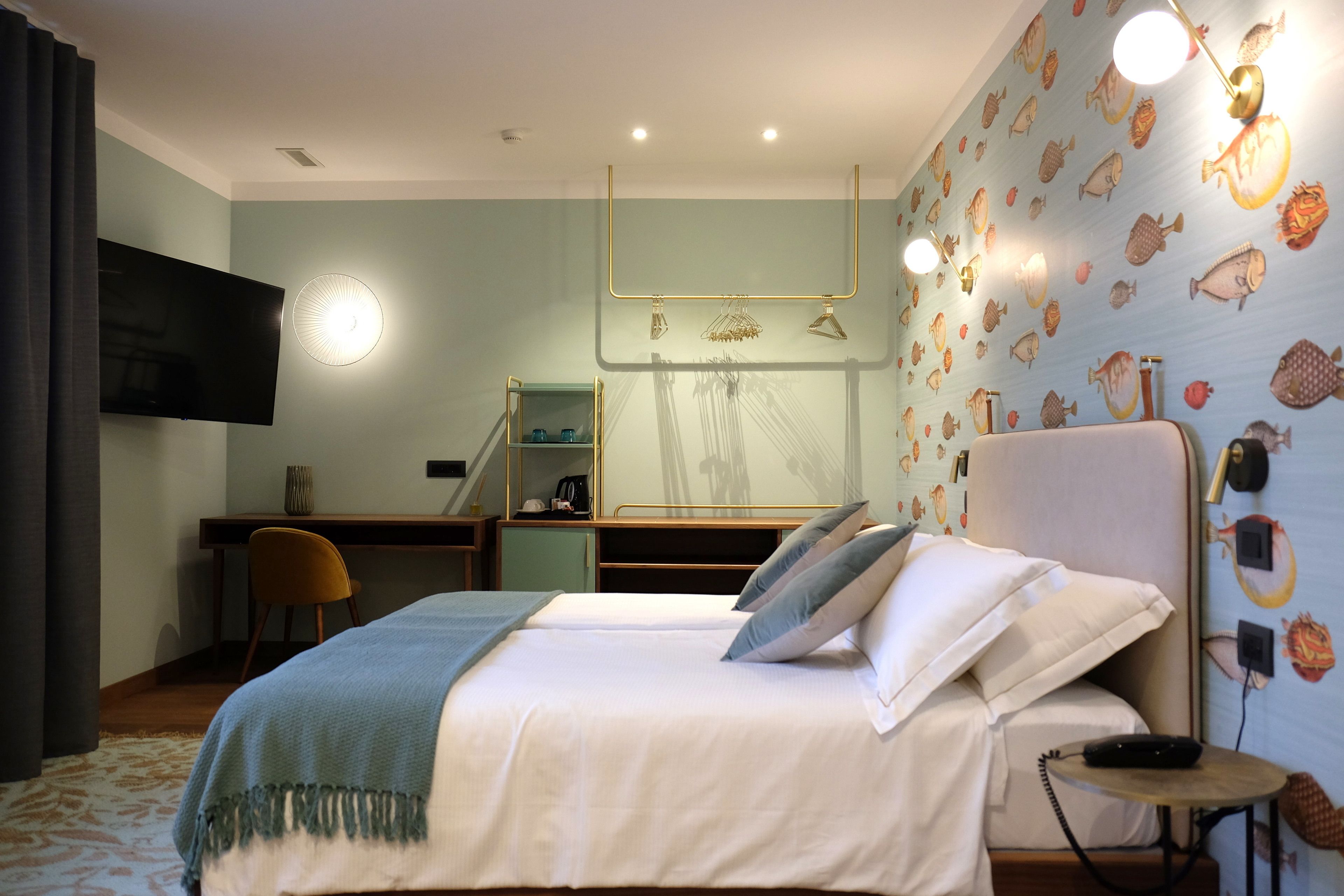 Une chambre d’hôtel équipée d’un lit, d’un bureau, d’une télévision et d’un espace douche.