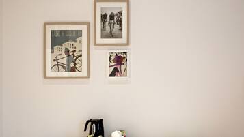 Ein Zimmer mit einem hölzernen Schreibtisch, einem weißen Stuhl und drei gerahmten Bildern an der Wand.