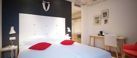 Una habitación de hotel moderna con una cama grande, un escritorio y una silla.