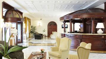 Un vestíbulo amplio con una imponente recepción, asientos cómodos y una decoración elegante.