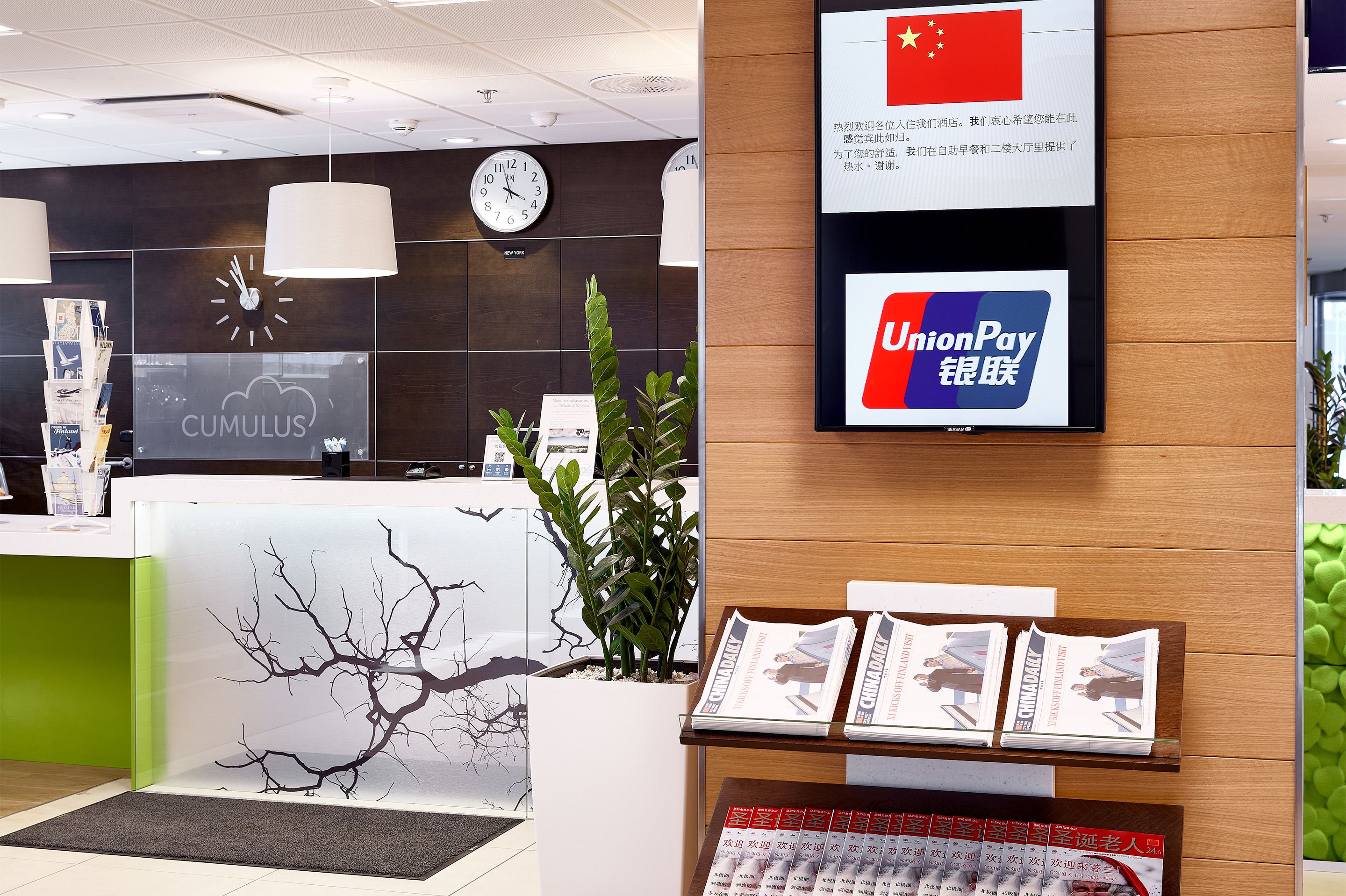 Una recepción con un reloj, un letrero de UnionPay y una exhibición de revistas.