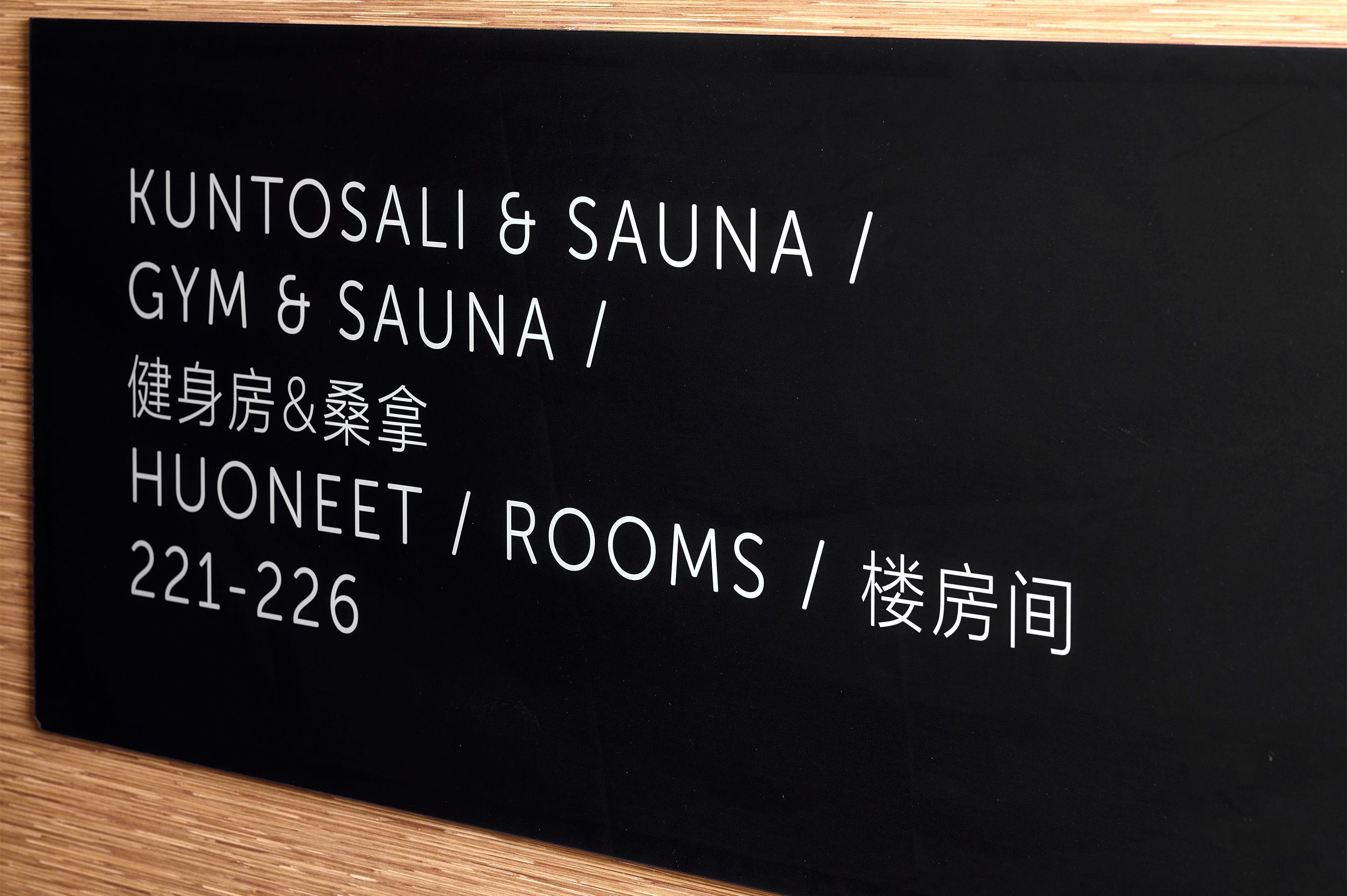 A black sign with white text listing room numbers 221-226, indicating rooms in a building.