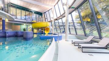 Relax by the pool with a view of the water's edge, surrounded by lounge chairs.
