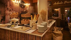A bakery counter with bread, pastries, and a coffee machine. - Scandic Aulanko (Hameenlinna)