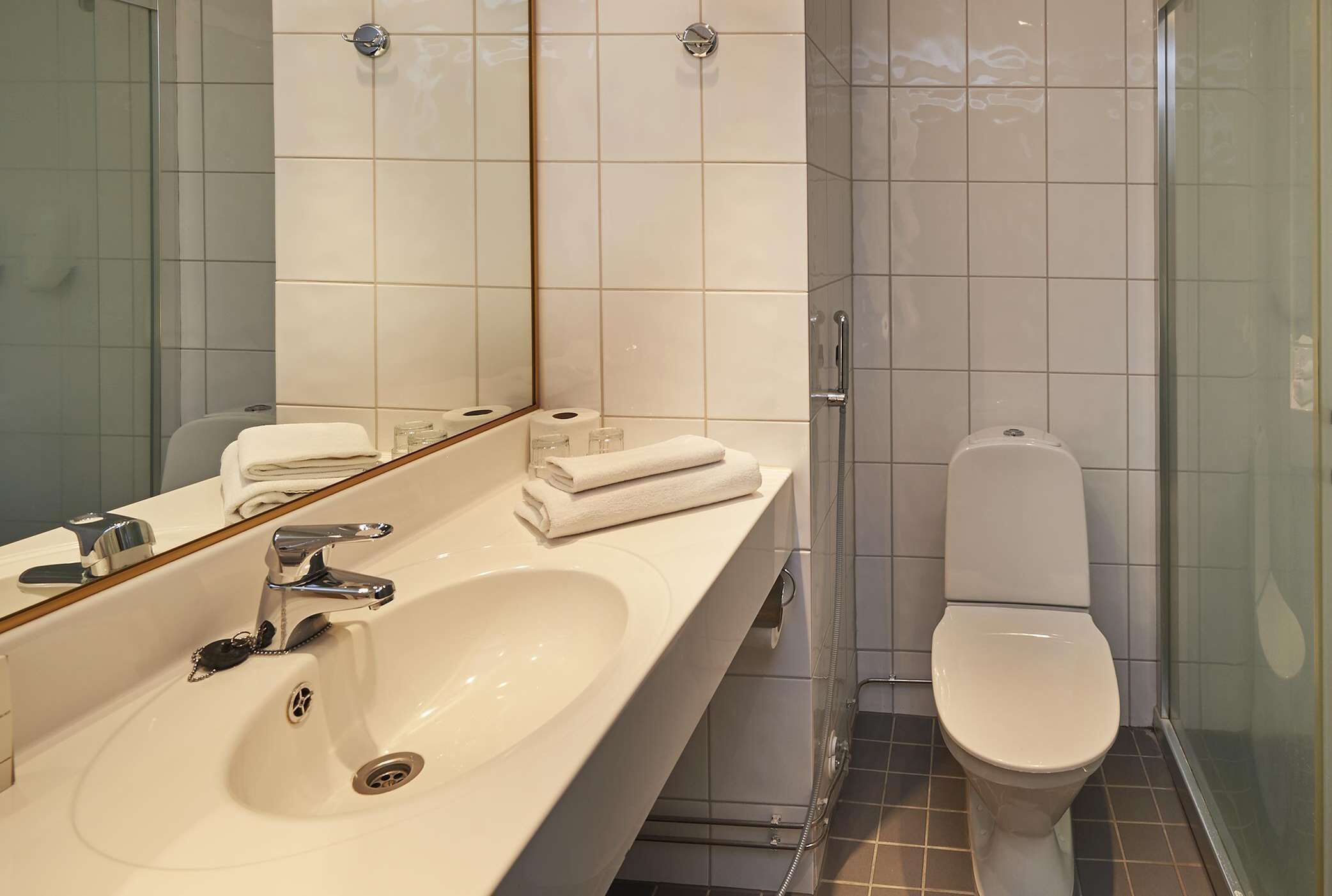 Ein Badezimmer mit Waschbecken, Spiegel und Toilette.