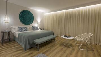 Ein modernes Schlafzimmer mit einem großen Bett, Nachttischen, einer Bank, einem Stuhl und einer runden Wanddekoration.
