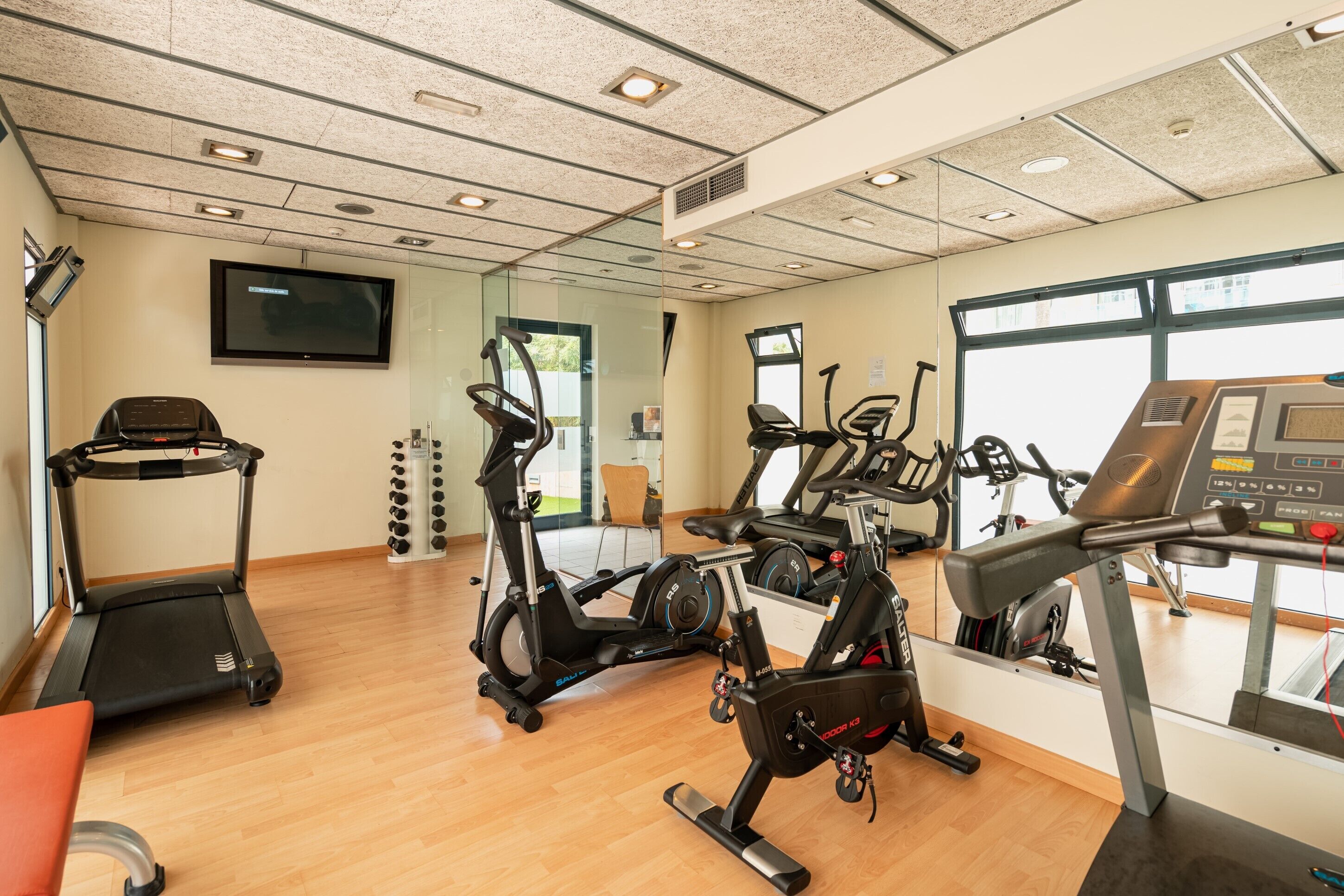 A gym with treadmills, stationary bikes, and a rowing machine.