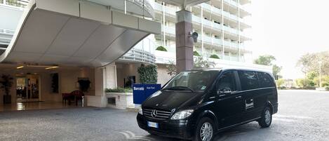 A black van parked in front of a building with a sign reading "Barcelo".
