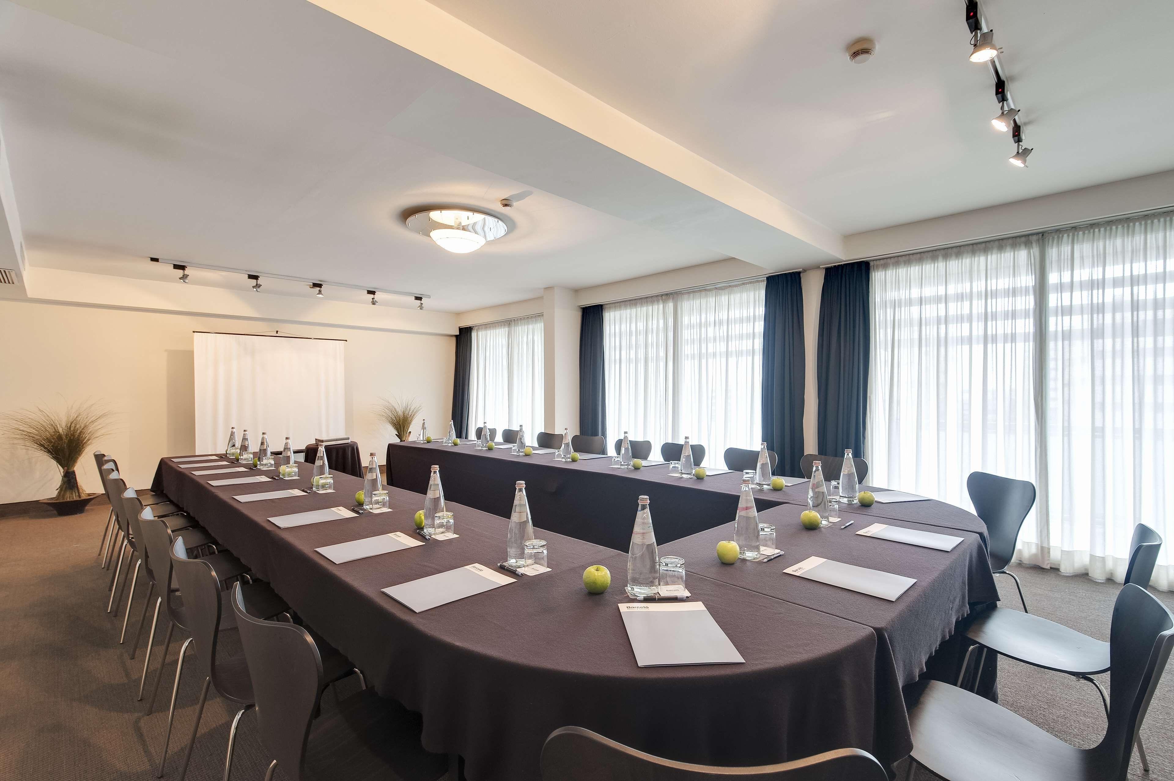 A conference room with a long table, chairs, water bottles, and nameplates.