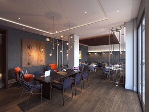 A modern dining area with a long table, multiple chairs, and pendant lighting.
