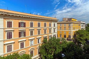 Un edificio de varios pisos con arquitectura clásica, destacando ventanas simétricas y una entrada central.