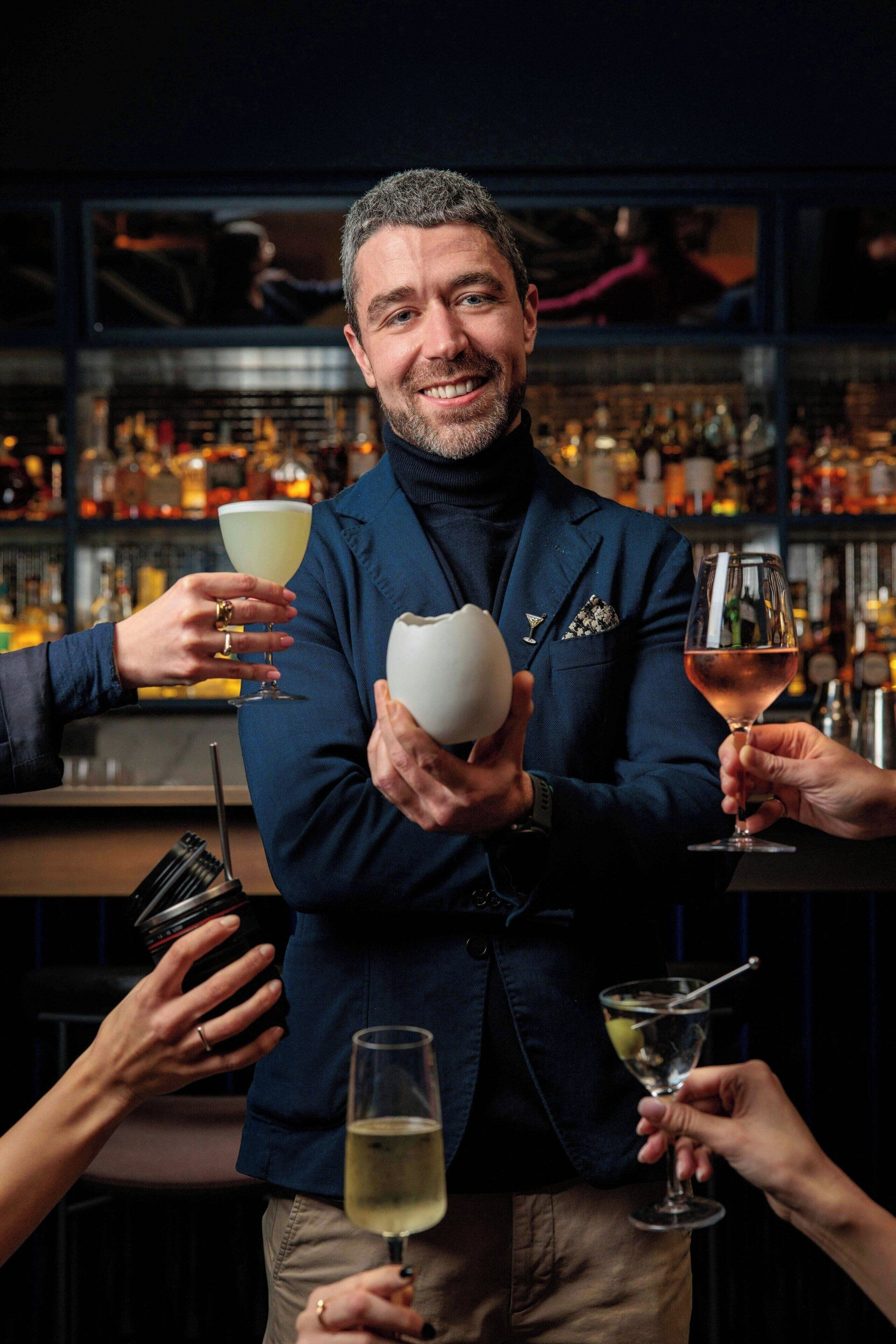 Une personne tenant un verre à cocktail, une autre tenant un verre à martini et une troisième tenant un verre à vin, avec un bar en arrière-plan.