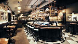 A bar area with a checkered floor, bar stools, and a central bar counter. - Bergstadens Hotel & SPA (Roros)