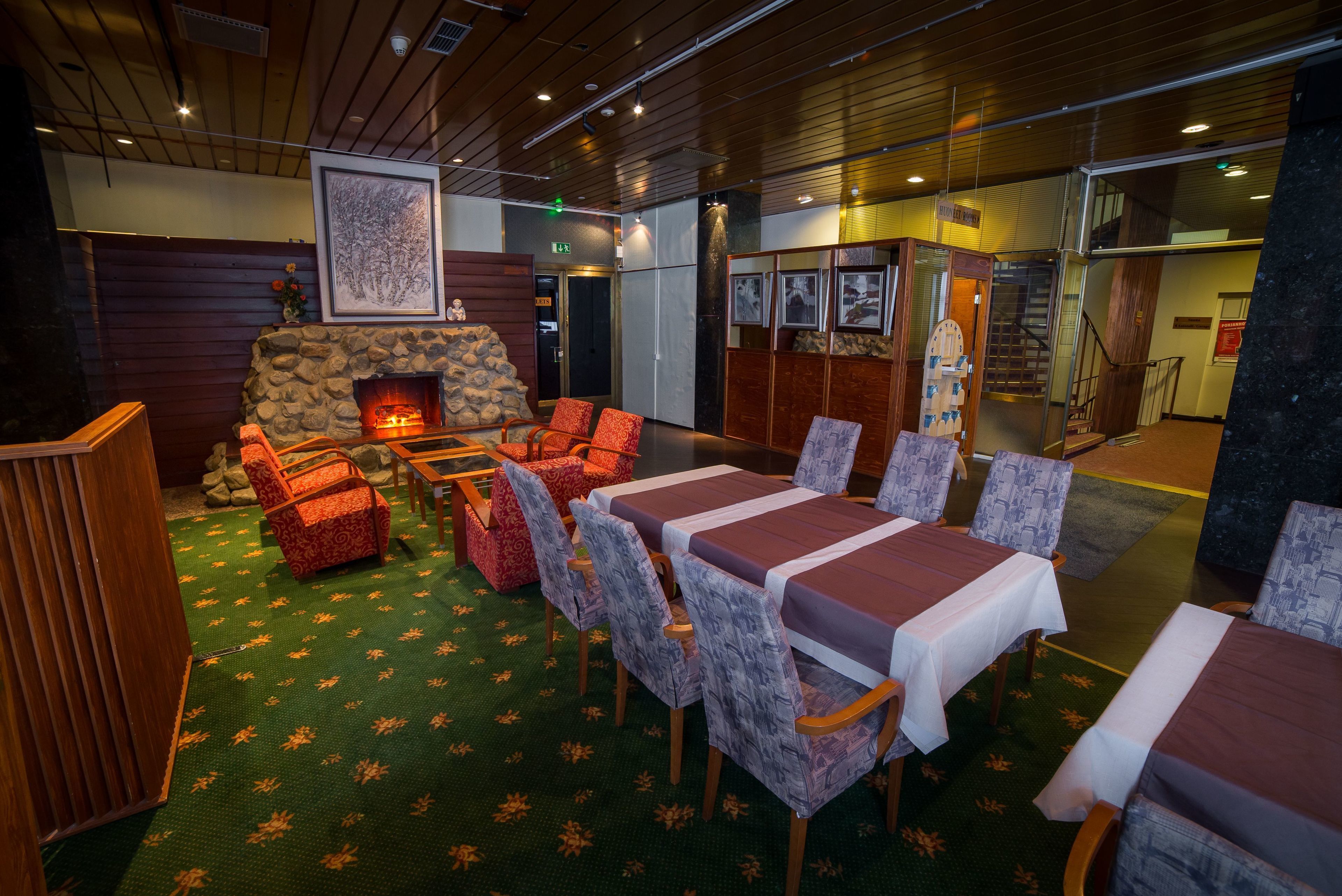 A cozy lounge area with a fireplace, comfortable seating, and a large table.