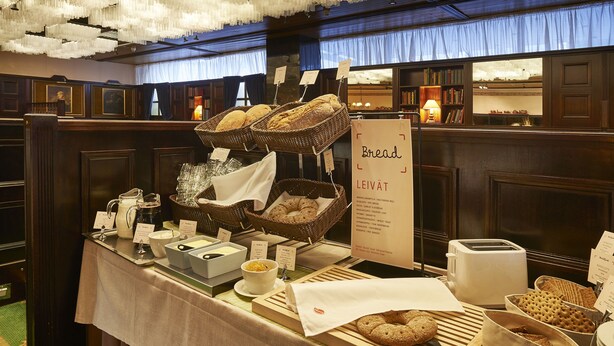 Un buffet de petit-déjeuner proposant un assortiment de pains, de viennoiseries et différentes sortes de café.