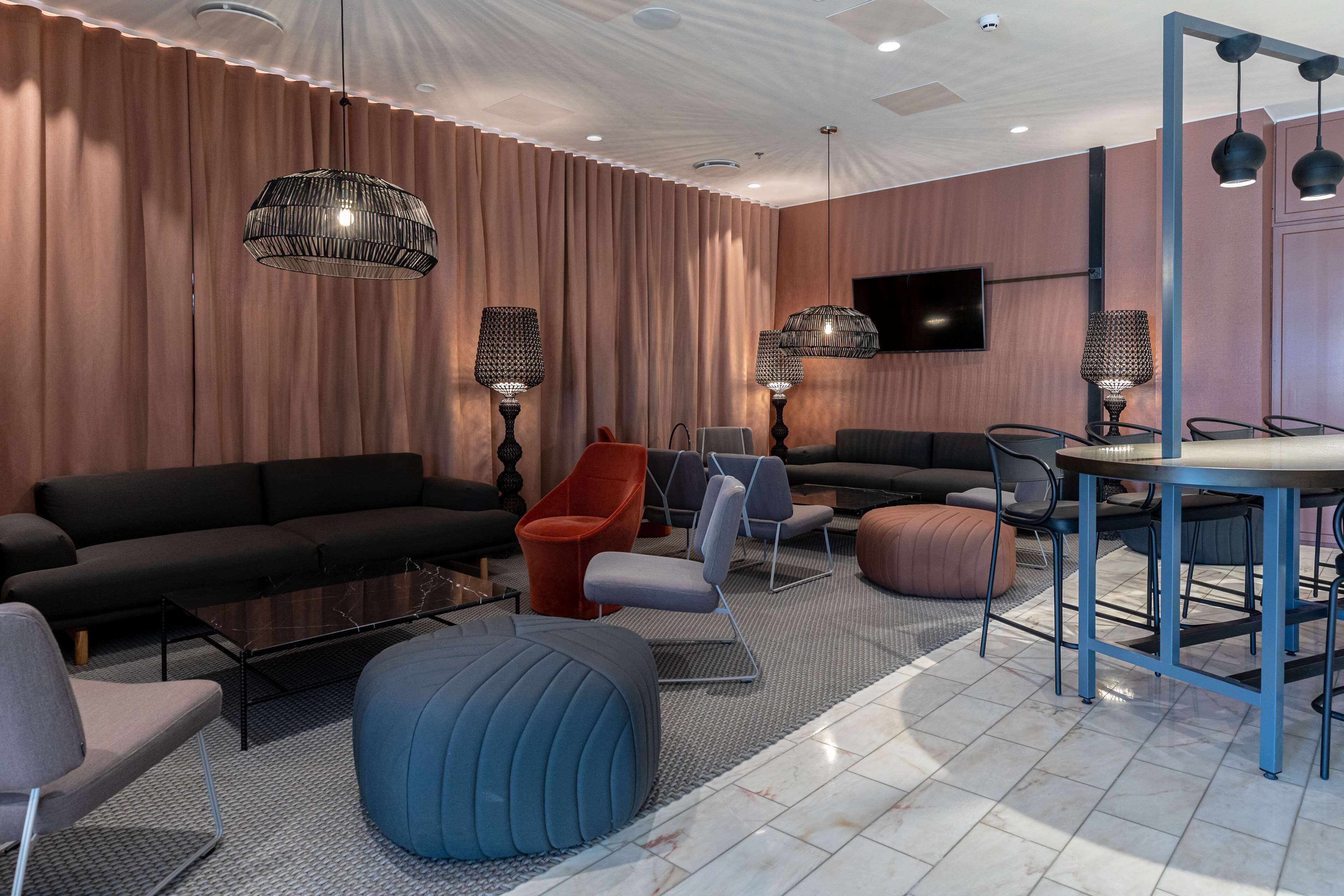 Uma sala de estar moderna com sofá, cadeiras, mesa de centro e canto de jantar com mesa e cadeiras.