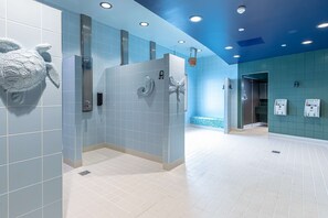 A modern bathroom with blue and white tiles, a shower area, and a wall-mounted towel rack.