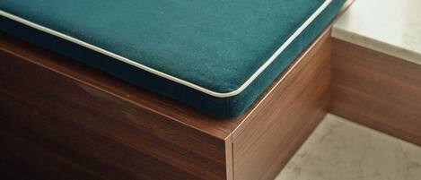 Un banco de madera con un cojín azul turquesa.