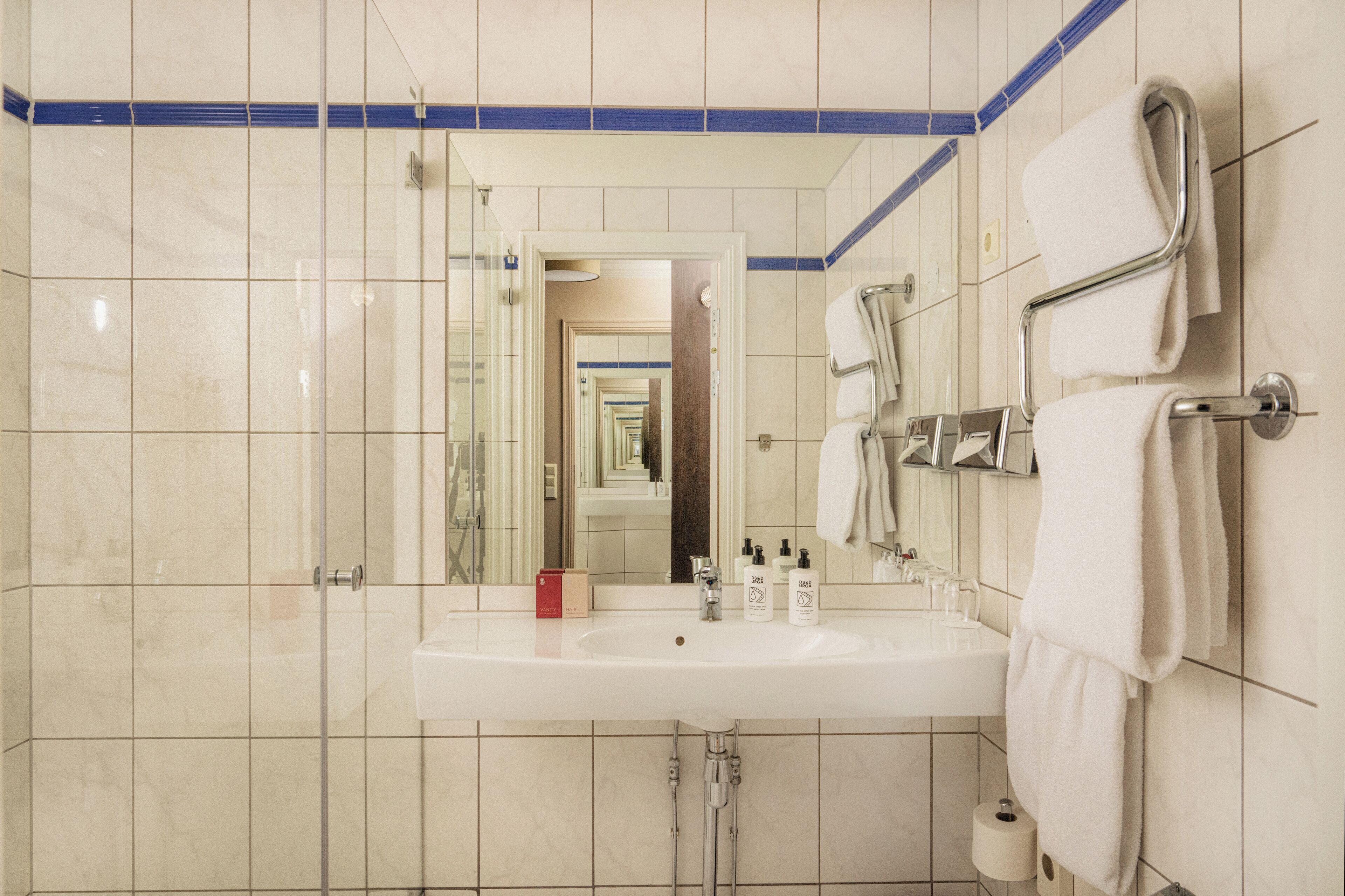 Ein Badezimmer mit Waschbecken, Spiegel und Handtuchhalter.