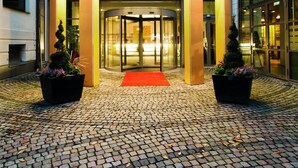The entrance of the Elite Stadshotel Vaxjo, featuring a circular facade, glass doors, and a red carpet leading to the entrance. - Elite Stadshotellet Växjö (Växjö)
