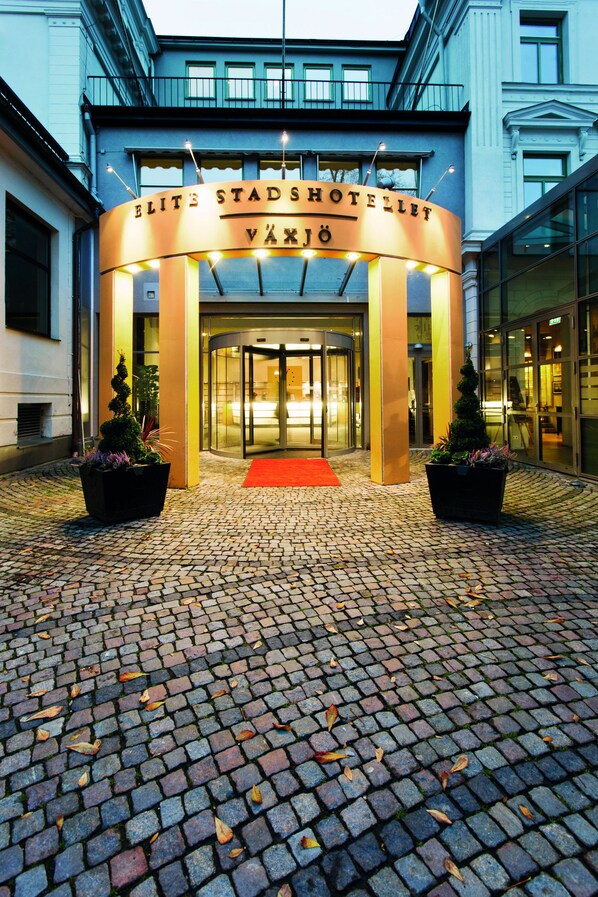 The entrance of the Elite Stadshotel Vaxjo, featuring a circular facade, glass doors, and a red carpet leading to the entrance. - Elite Stadshotellet Växjö (Växjö)
