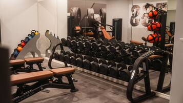A gym with weight racks, benches, and exercise equipment.