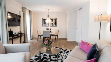 Suite, 1 cama matrimonial | Área de sala de estar | Televisión de pantalla plana