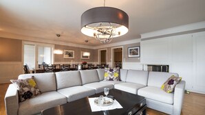 A modern living room with a sectional sofa, a coffee table, and a chandelier. - Scandic Fauske Hotel (Fauske)