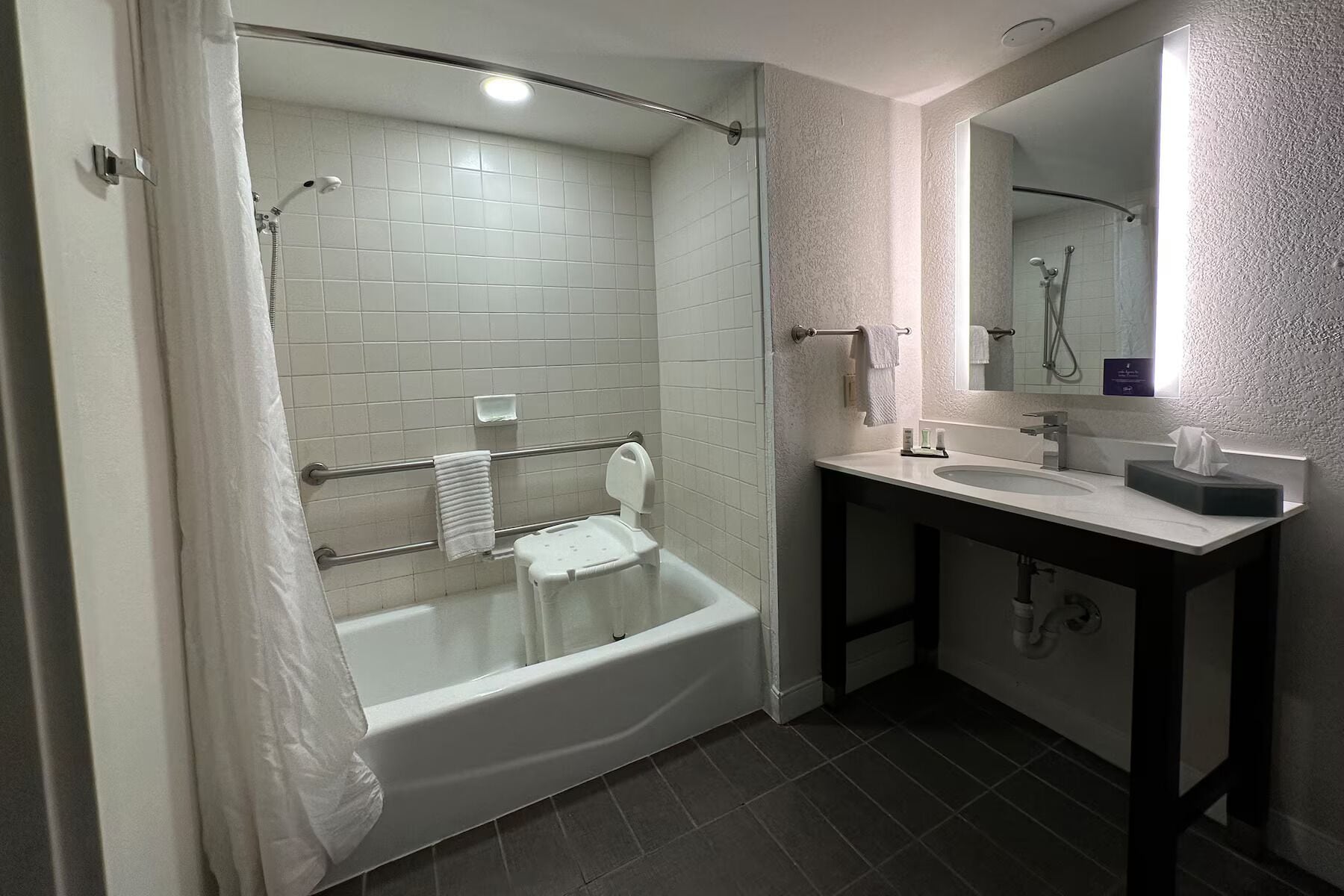 A modern bathroom with a bathtub, a shower, and a sink.