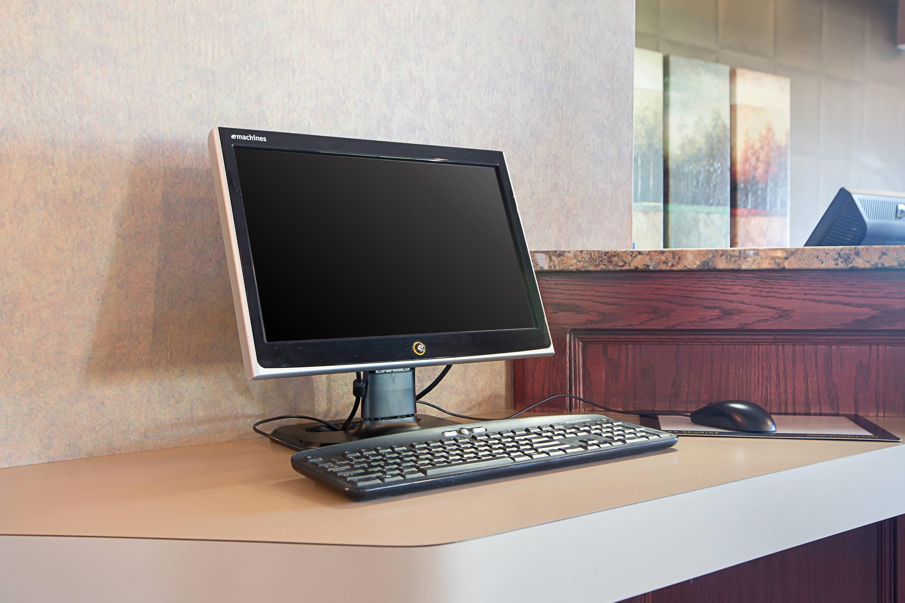 A computer setup on a desk with a monitor, keyboard, and mouse.