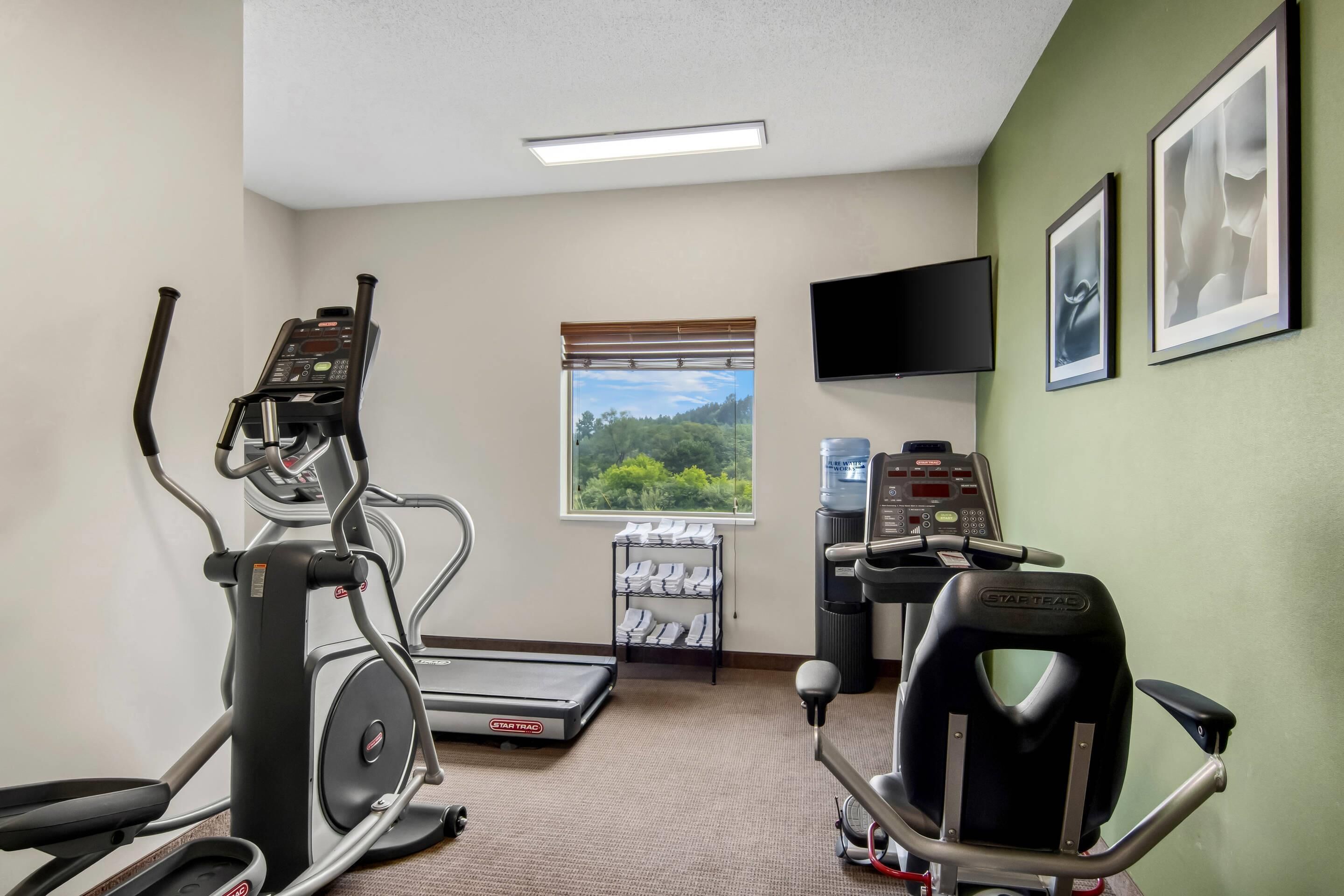 A gym with treadmills, an elliptical, a stationary bike, and a rowing machine.