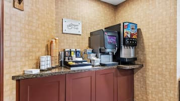 A coffee station with a coffee machine, a beverage dispenser, and a sign that reads 'Dream Cup.'
