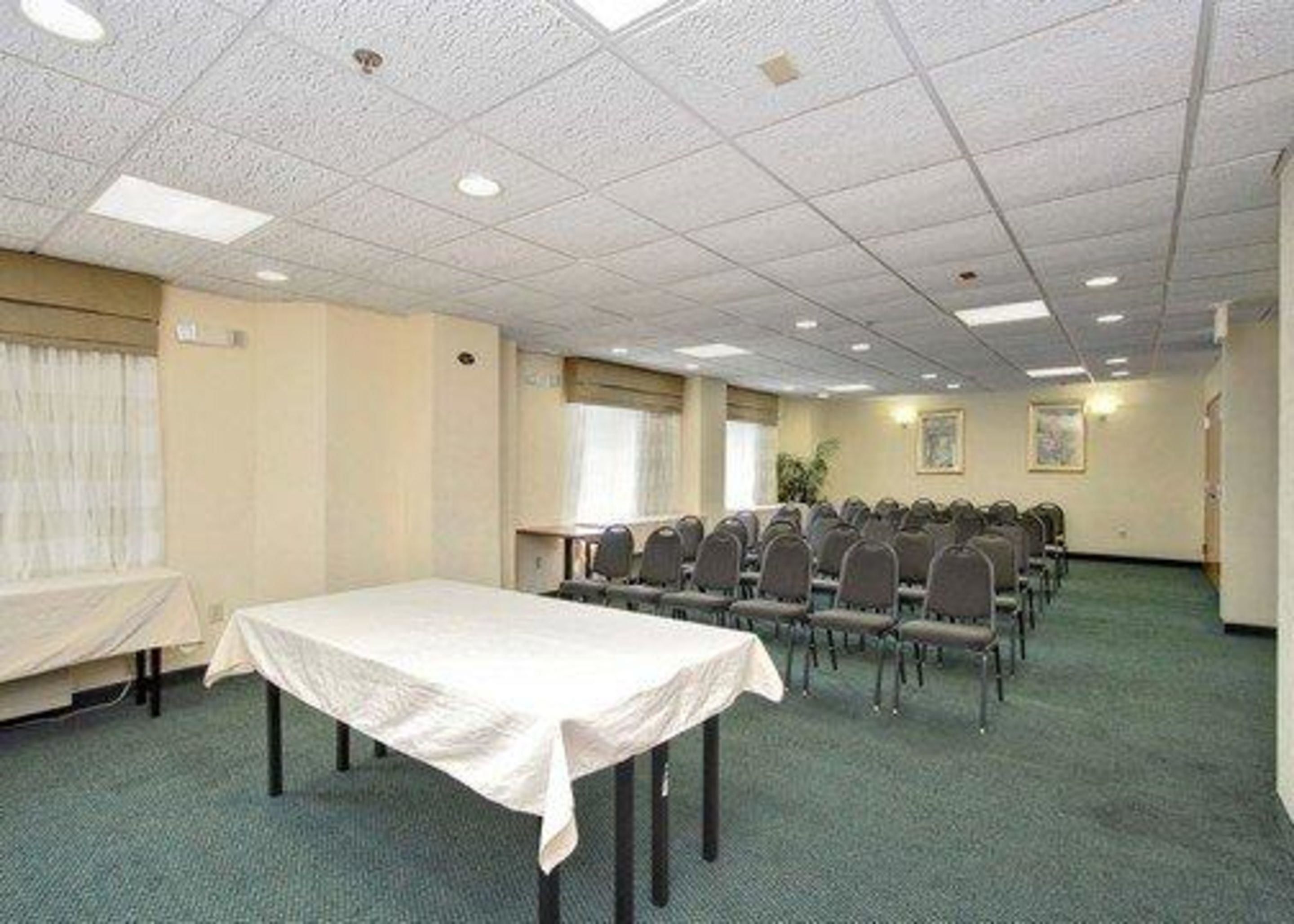 A conference room with a long table, rows of chairs, and a carpeted floor.