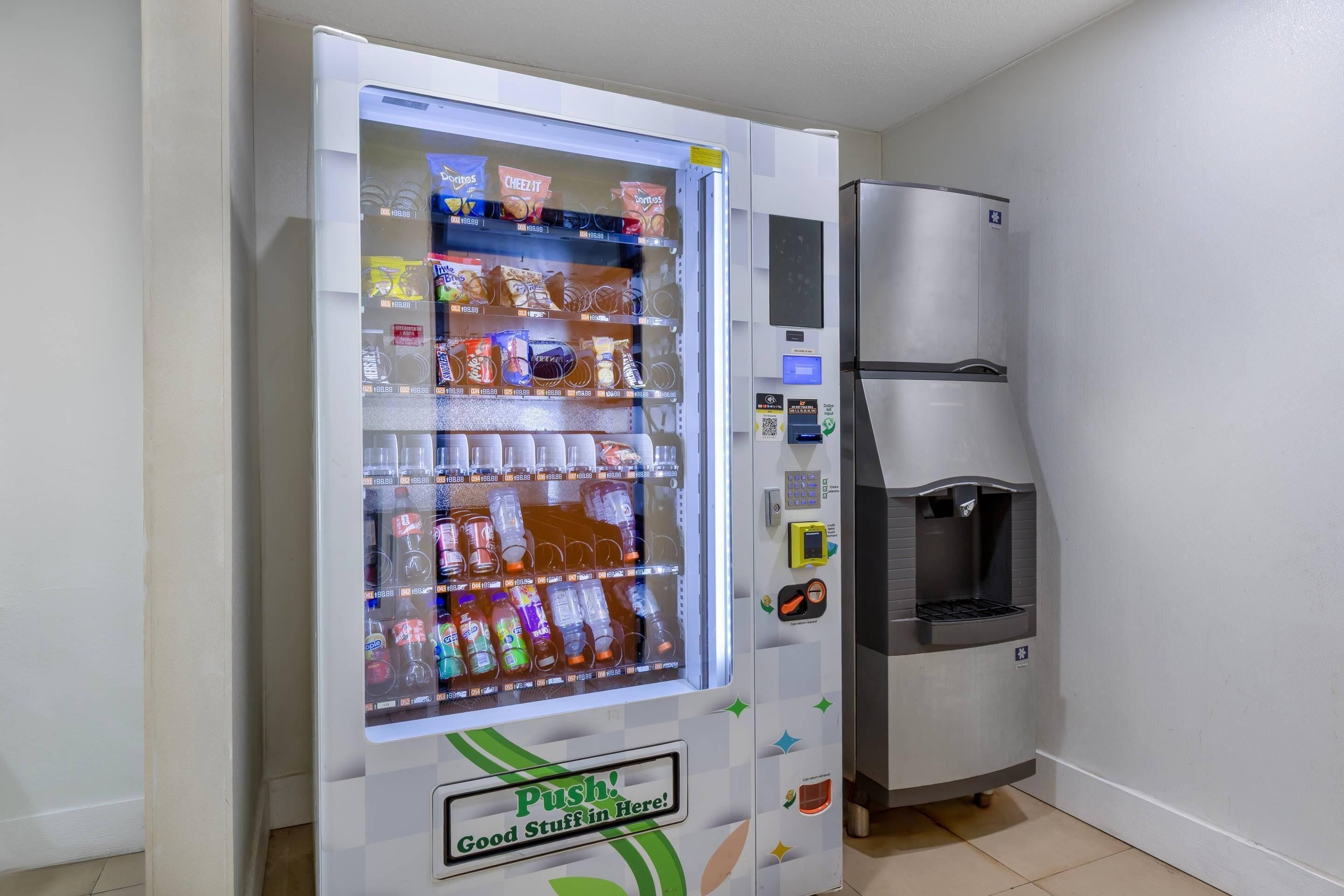 A vending machine with snacks and drinks, a water dispenser, and a push button.