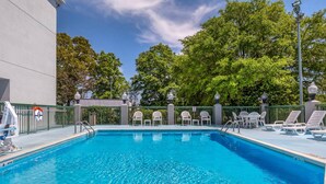 A swimming pool with lounge chairs and a lifeguard stand. - Sleep Inn Garner - Clayton (Garner)