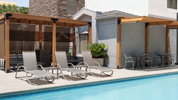 A poolside area with lounge chairs and a pergola structure. - Garner Hotel Aiken South by IHG (Aiken)