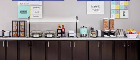 A breakfast bar with various food items and beverages.