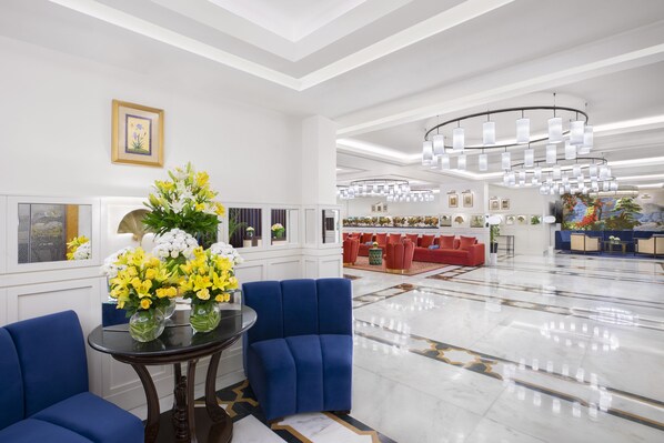 A spacious lobby with a marble floor, blue seating, and a large chandelier. - Tajview,Agra-IHCL SeleQtions (Agra)