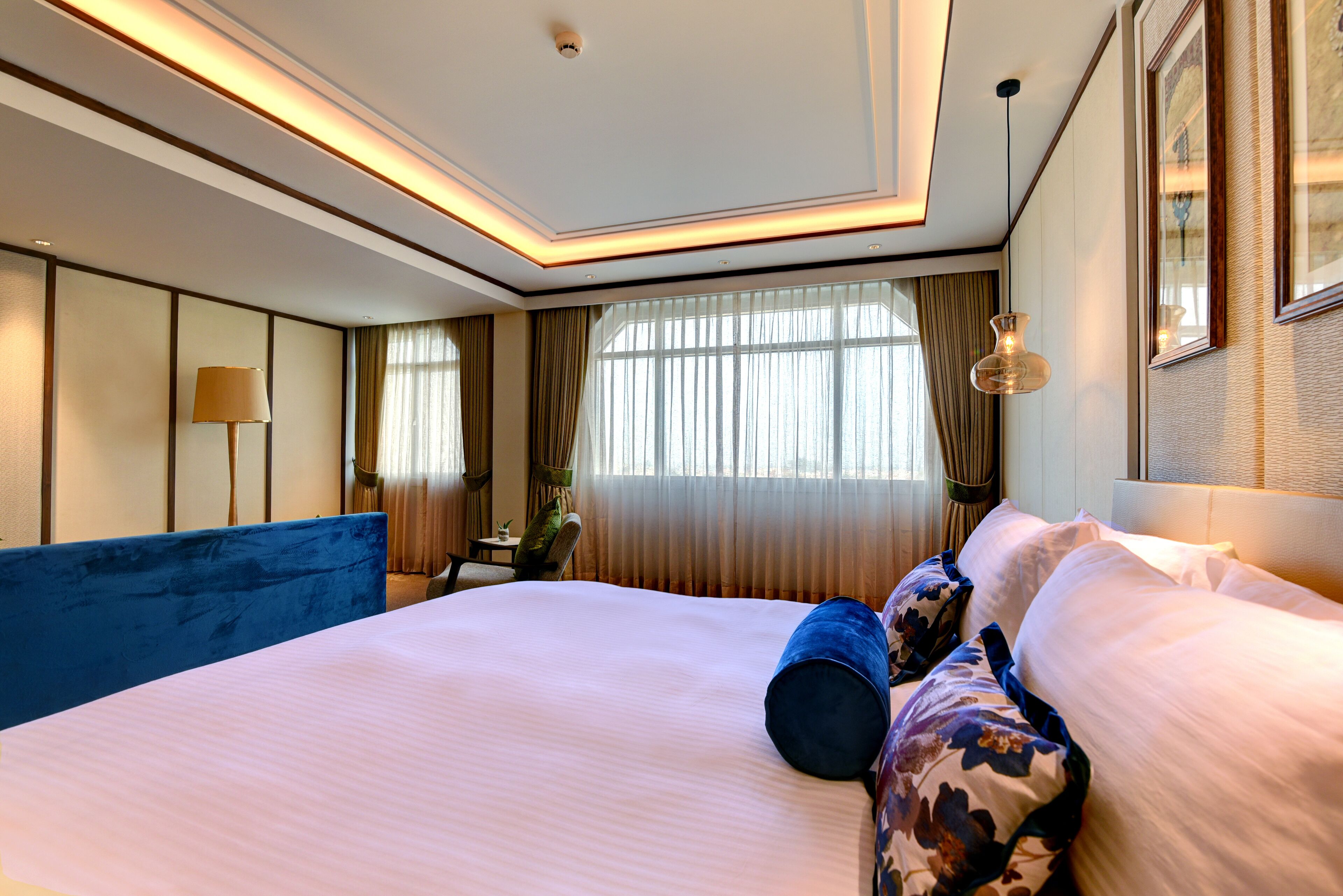 A hotel room with a large bed, a desk, and a chair.