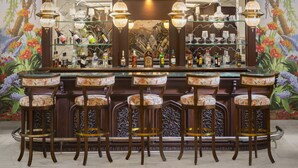 A bar area with a circular bar counter, multiple stools, and hanging pendant lights. - Tajview,Agra-IHCL SeleQtions (Agra)