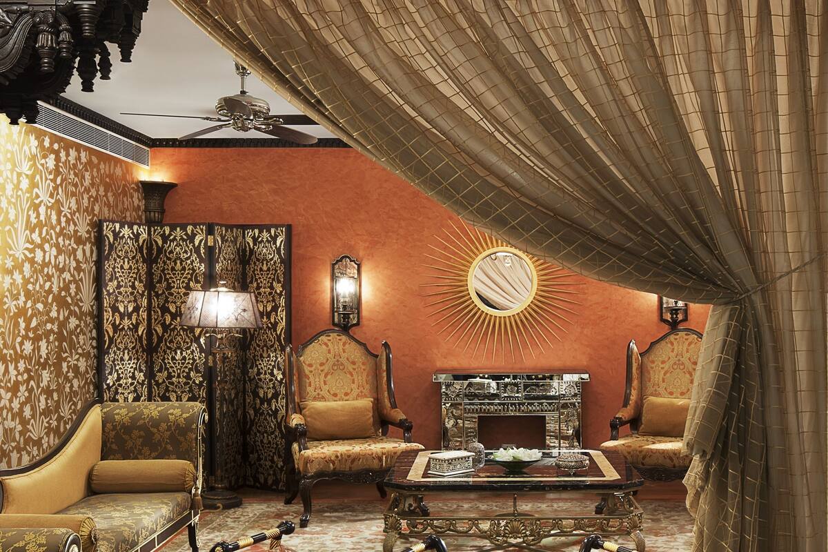 A traditional room with ornate furniture, a patterned carpet, and a decorative fireplace.