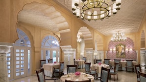Un espace repas avec des tables rondes, des chaises, des lustres et des éléments décoratifs.