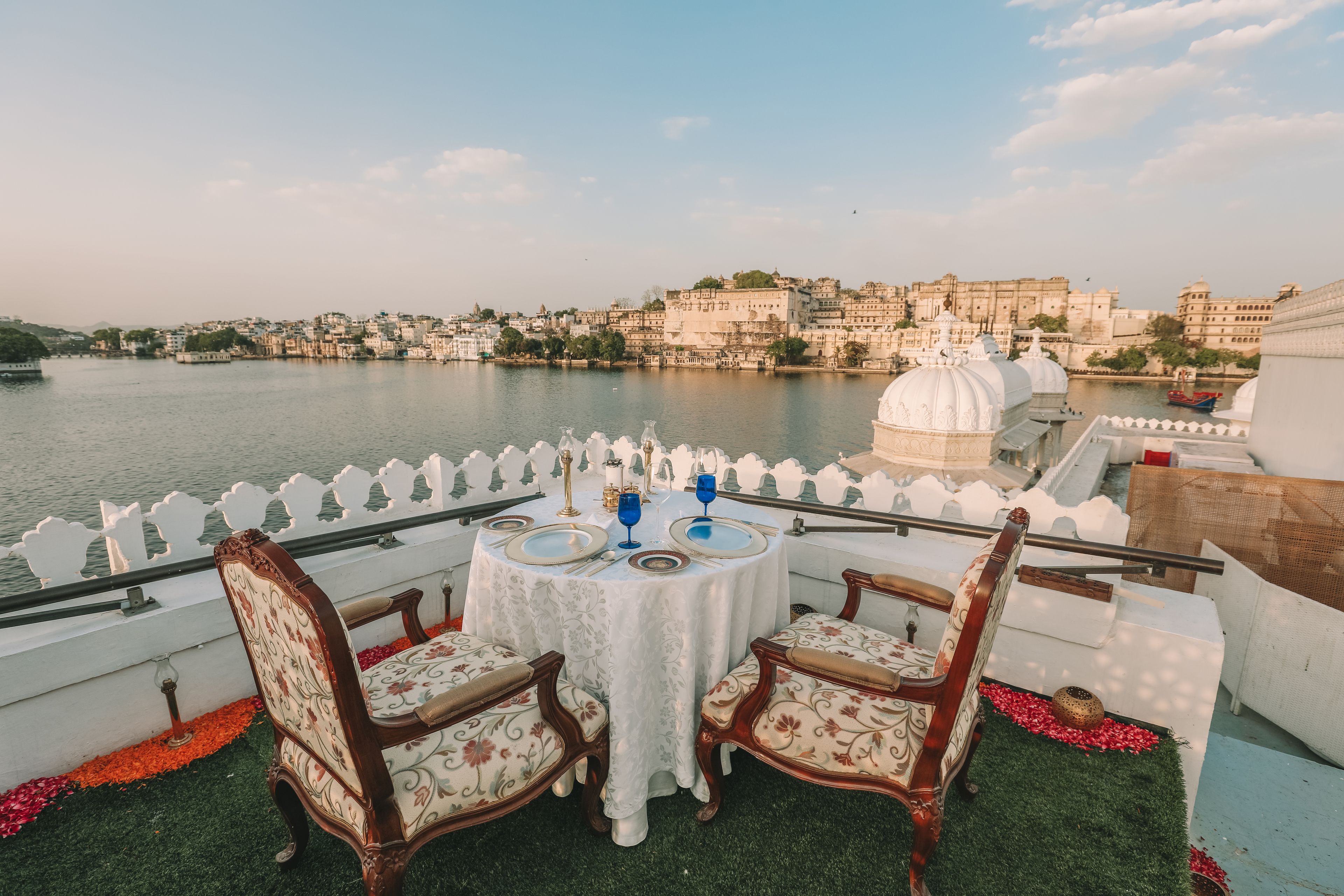 A table set for two with a view of a historic cityscape across a river.