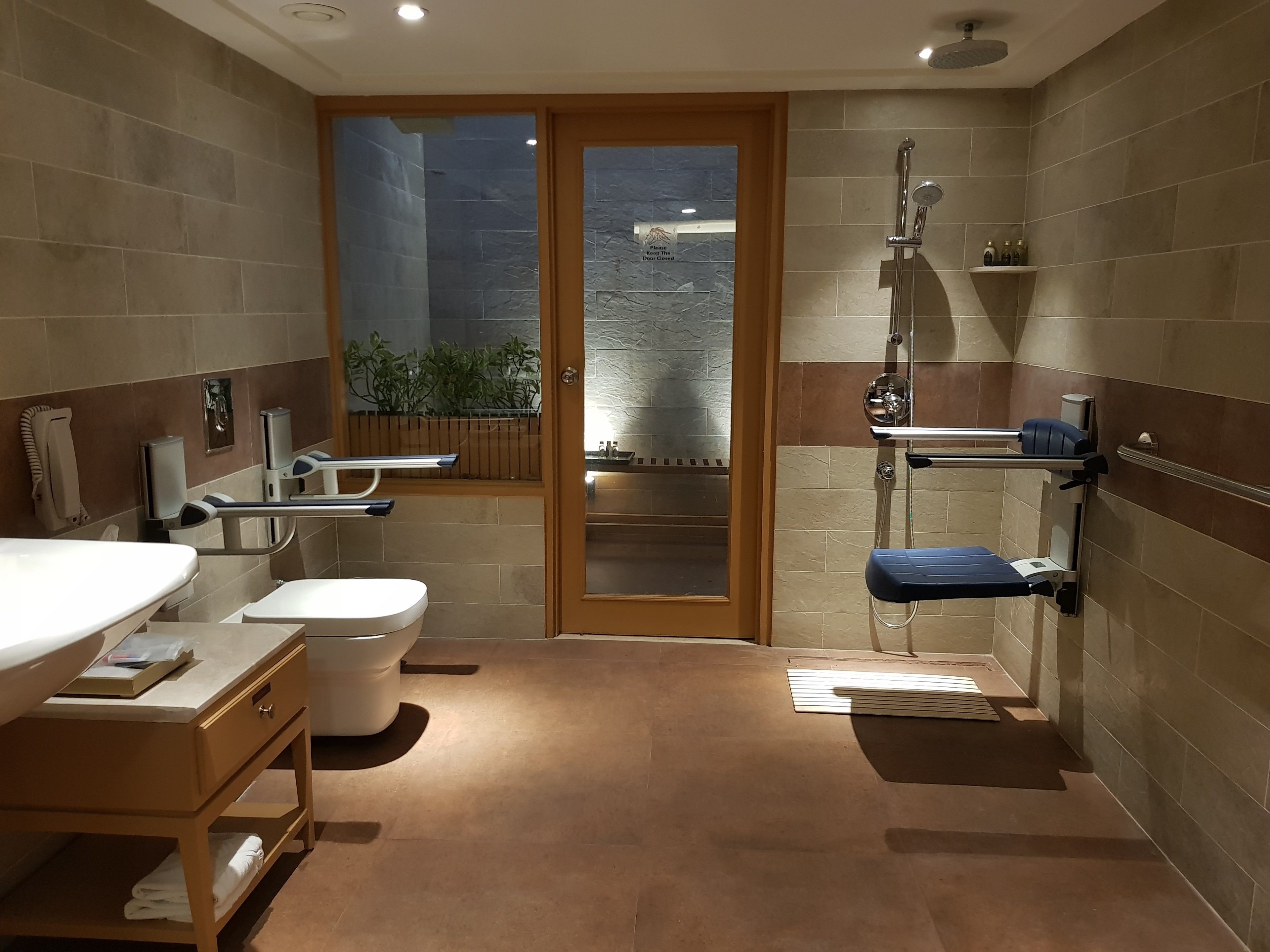 Een moderne badkamer met toilet, wastafel en douche.