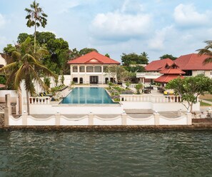 Una piscina al aire libre, sombrillas, sillones reclinables de piscina
