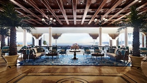 A spacious lobby with a wooden ceiling, large windows, and a view of the ocean. - Taj Fort Aguada Resort & Spa, Goa (Candolim)
